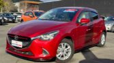 front side view of red 2015 Mazda Demio