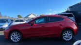 full side view of red 2015 Mazda Axela