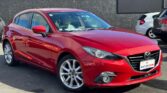 side view of red 2014 Mazda Axela