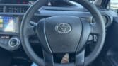 steering wheel view of white luxury 2017 Toyota Aqua